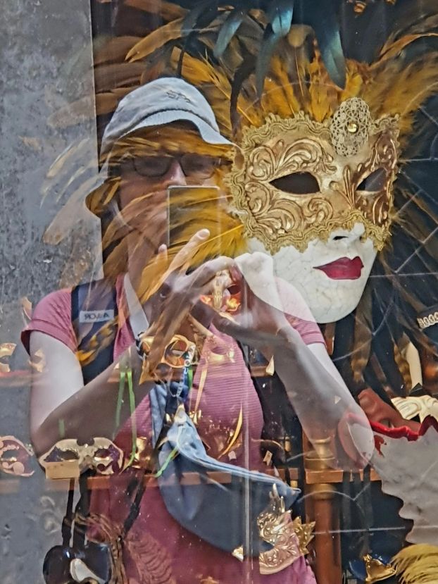 Masken und Tourist in Venedig