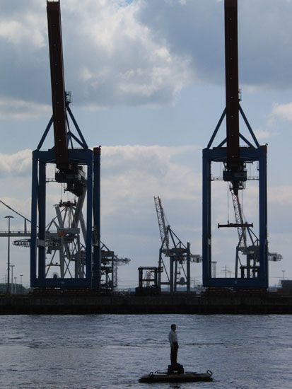 Mann in der Elbe vor Containerterminal